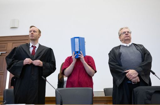 Der Angeklagte im Prozess um den Mord an der 14-jährigen Ayleen verbirgt sein Gesicht hinter einem Aktenordner. Foto: dpa/Boris Roessler
