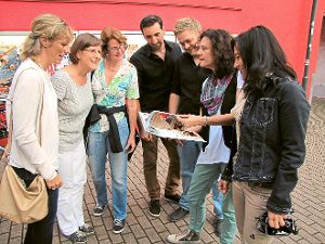 Einige der Laienschauspielerinnen schauen sich gemeinsam den Fotoband über das Firobe-Fescht-Spiel mit den Filmemachern Marco Schmid und Manuel Eckert an. Foto: Wölfle