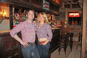Das Cowboy-Flair ist einfach toll: Jessica und Jens Wilde in ihrer Western-Bar vor der alten Sonnen-Theke. Foto: Wagener