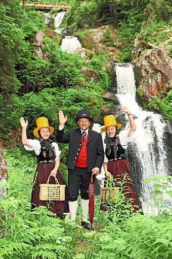 Das  Trachtentrio lädt zum Schinkenfest beim Wasserfall ein.  Foto: Stadtverwaltung Foto: Schwarzwälder-Bote