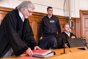 Der Angeklagte Drazen D. (gebückt) mit seinen Anwälten und einem Justizmitarbeiter beim Prozessauftakt. Foto: Graner
