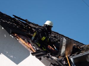 Ein Feuerwehrmann entfernt Dachziegel. Foto: Heidepriem