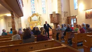 Jürgen Beckmann erzählt den Besuchern aus der Geschichte der Isinger Kirche. Foto: Privat Foto: Schwarzwälder-Bote