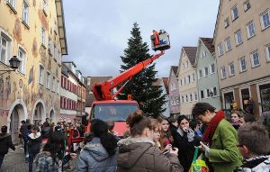 Klangkünstlerin Monika Golla (grüne Jacke) verteilt die Schoko-Weihnachtsmänner. Der Bauhof verteilt in der Zwischenzeit den Schüler-Schmuck. Foto: Hopp
