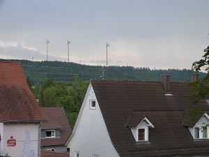 Etwa dreieinhalb Mal so hoch wie die bestehenden Strommasten würden Windräder auf der hinter dem Wald liegenden  Anhöhe  im Süden Deißlingens vom Ort aus ins Blickfeld rücken. Foto: Scheidel, Montage: Rörsch Foto: Schwarzwälder-Bote
