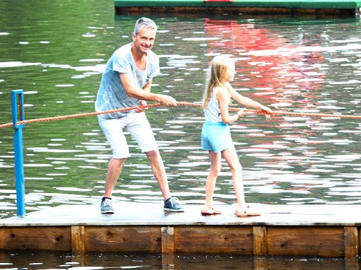 Thomas Rüsing und Tochter Charlotte ziehen sich am Lichterfest mit einem Floß über den Klostersee.  Foto: Bombardi Foto: Schwarzwälder-Bote