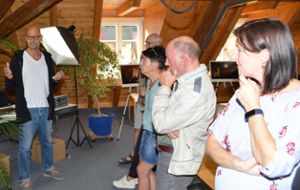 Künstler Uwe Merz (links) schildert den Besuchern der Vernissage, wie er die Bilder fotografiert hat. Fotos: Herzog Foto: Schwarzwälder Bote