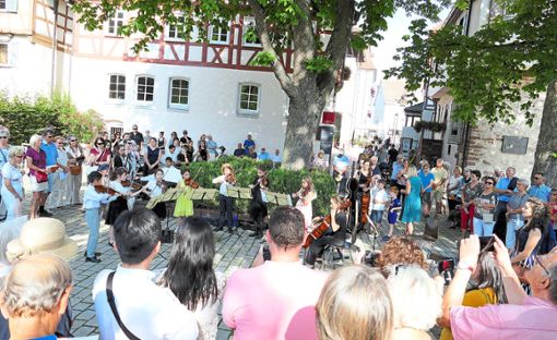 Als die Musiker beim Wandelkonzert auf dem Longwyplatz  Halt machten, um zu spielen, war die Menge der Zuschauer auf mehr als 200 angewachsen.  Foto:  Stadler