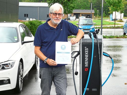 Stolz präsentiert Ulrich Fux, hier neben der Elektrotankstelle, die Anerkennungsurkunde für den kohlenstoffdioxid-neutralen Betrieb. Foto: Eitel Foto: Schwarzwälder Bote