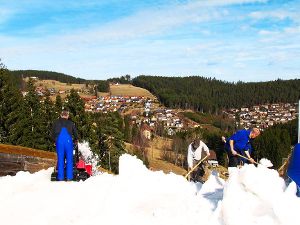 Schneeverarbeitung im Frühling: Die Schonacher Helfer, hier an der Schanze, geraten heftig ins Schwitzen. Foto: Skiclub