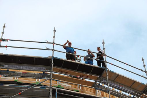 Die Handwerker bei ihrem Richtspruch auf dem Dach des Gebäudes. Fotos: Hilbertz Foto: Schwarzwälder Bote