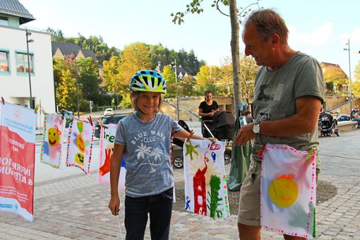 Endlich darf Matti seine Fahne mit nach Hause nehmen: Erich Laub hilft  dem Neunjährigen, sein Werk – eines von mehr als 300 – abzuhängen. Foto: Thiercy Foto: Schwarzwälder Bote