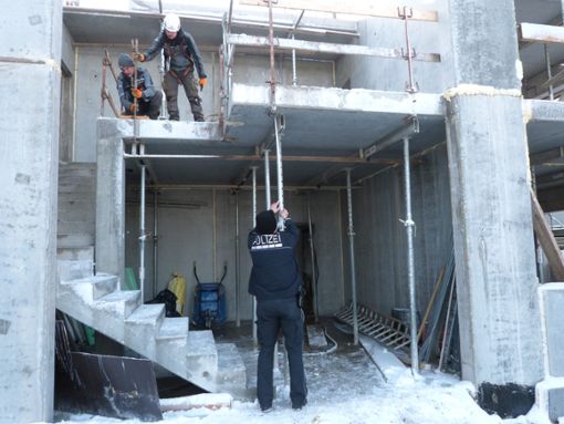 Von der oberen Betonplatte ist der Arbeiter gestürzt. Ein Polizist macht sich ein Bild von der Baustelle. Foto: Merk