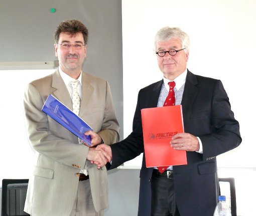 Volker Viniol (rechts) und Arno Ayasse tauschen die Vertragsunterlagen aus.  Foto: Hofmann