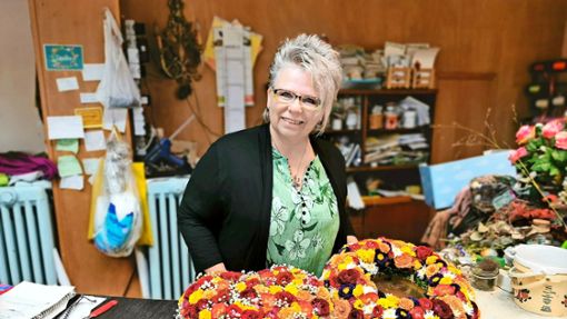 Die Bestatterin Beate Sauter präsentiert einen Blumenkranz und ein Blumenherz, die sie für eine Beerdigung gestaltet hat. In ihrem Beruf hat sich in den vergangenen Jahren einiges verändert. Foto: Aileen Ginter