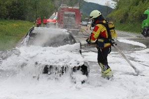 Feuerwehrleute löschen am Dienstag einen brennenden Mercedes auf der B31 bei Hinterzarten. Foto: Kamera24.TV