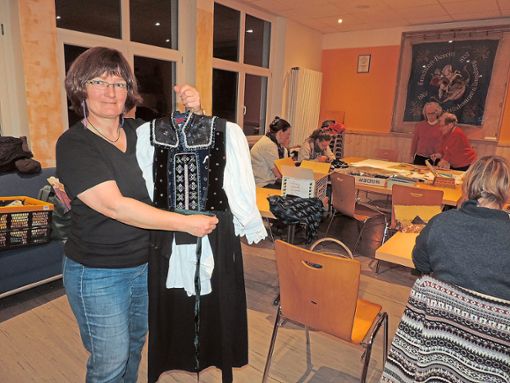 Inventarverwalterin Marion Borho zeigt, wie die Kleidung richtig angezogen wird. Foto: Paskal Foto: Schwarzwälder Bote
