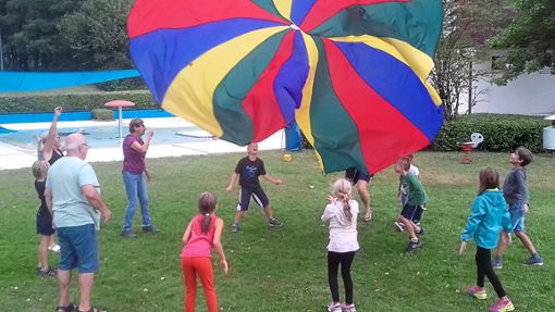 Das gemeinsame Spielen mit einem Fallschirm am Beckenrand des Freibads machte den Kindern besonderen Spaß. Foto: Glaser Foto: Schwarzwälder Bote