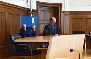 Der Angeklagte verbarg sein Gesicht vor der Urteilsverkündung hinter einem Aktenordner. Foto: Günther