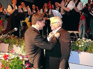 Bürgermeister Klaus Mack (links) heftete dem langjährigen Musikverein-Geschäftsführer Helmut Bürkle die Landesehrennadel an. Foto: Schwarzwälder-Bote