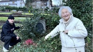 Erst nach langem Suchen entdecken Gerdi Sobek-Beutter und ihr Enkel Julian den Grabstein ihres Ur-Großvaters, der mit Efeu überwuchert ist. Foto: Zoller