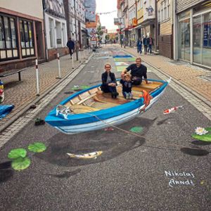 tDas ist 3D-Kunst: Ein Boot steht mitten auf der Straße und darin sitzt eine Familie. Foto: Arnd Foto: Schwarzwälder Bote