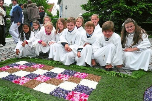 Die Ministranten bewundern den schönen Blumenteppich in Donaueschingen-Aasen. Foto: Winkelmann-Klingsporn Foto: Schwarzwälder Bote