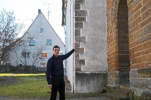Auch Pfarrer Johannes Zimmermann kann das Datum auf der Außenmauer der Kirche nicht genau entziffern. Foto: Fischer