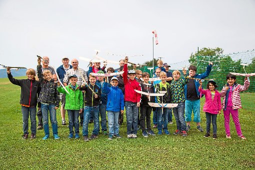 16 Kinder der Sommerferienspiele  präsentieren  ihre  selbst gebastelten Balsaflieger, die sie mit den   Helfern   der Zillhausener Modellfliegergruppe gebaut haben. Foto: Deregowski Foto: Schwarzwälder-Bote