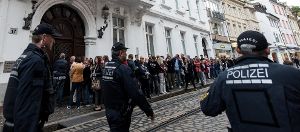 Besucher, Journalisten und Polizisten stehen vor Prozessbeginn vor dem Landgericht Freiburg. Foto: dpa