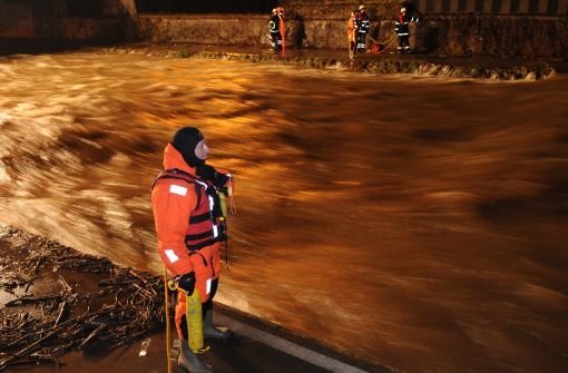 Feuerwehrmänner suchen am Dienstagabend in Freiburg den Fluss Dreisam ab. Nach Polizeiangaben hatte ein Mann versucht, ein Fahrrad aus dem Hochwasser führenden zu bergen. Plötzlich verschwand er im Wasser. Mehr als 100 Kräfte suchen den Mann. Bis zum späten Abend war diese erfolglos.  Foto: dpa