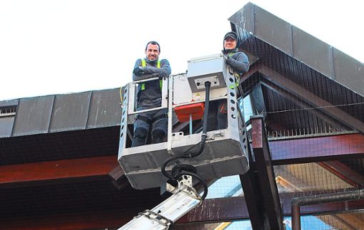 Frane Petricevic (links) und sein Kollege Luka Petrovic von der Firma Aktiv Taubenabwehr befestigen ein neues Netz gegen Tauben an der bereits verschmutzten Stadtbibliothek.  Foto: Parage