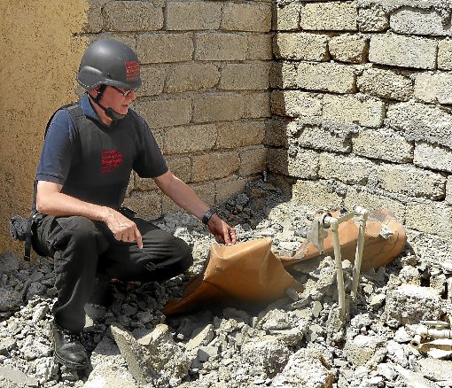 Ein Mitarbeiter der deutschen Hilfsorganisation schaut sich die Bombe im zerstörten Haus an.   Foto: Freunde der Erziehungskunst