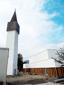 Der neue Kirchenbau passt stilistisch zu dem einzeln stehenden Turm, der vom Brand am 13. März 2011verschont worden war. Foto: Schnurr