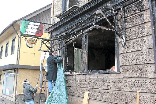 Mario Detta (Leiter) vernagelt drei Tage nach dem Brand die Fenster seiner Pizzeria in der Oberndorfer Straße. Foto: Kammerer