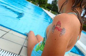 Ein Mädchen mit einem »NO!«-Klebetattoo am Arm im Freibad von Tettnang. Foto: Hildenbrand