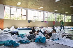 Flüchtlinge liegen am  in der Landeserstaufnahmeeinrichtung für Flüchtlinge in Ellwangen in einer Turnhalle. Foto: dpa