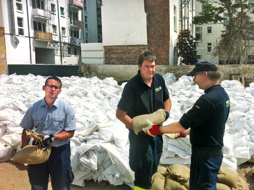 Packen kräftig an im Hochwassergebiet bei Magdeburg und verteilen Sandsäcke (von links): Steven Nauditt (THW OV Trossingen) sowie Bastian Stieren und Ulf Zollondz (beide THW OV Rottweil). Foto: THW Rottweil