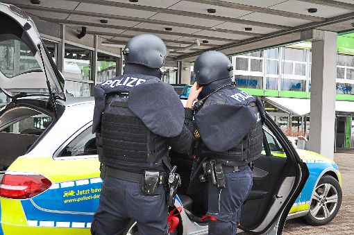 Polizisten legen vor dem Schulzentrum ihre Schutzausrüstung an.  Foto: Müller