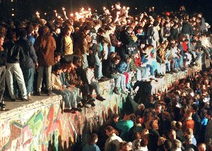 Nach der Öffnung der deutsch-deutschen Grenze in der Nacht auf den 10. November 1989 reisten Millionen DDR-Bürger für einen kurzen Besuch in den Westen. Auf dem Foto sitzen jubelnde Menschen am 11. November 1989 auf der Berliner Mauer. Foto: dpa
