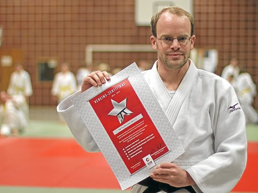 Stefan Lippert, Leiter der Judoabteilung Freudenstadt, hält stolz das Vereins-Zertifikat in die Kamera, das der Judoabteilung eine hohe Qualität bescheinigt.   Foto: Wahr Foto: Schwarzwälder-Bote