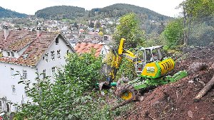 Spezial-Bagger gräbt Erdrutsch-Reste weg