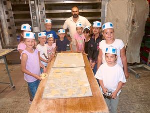 Die Kinder, hier mit Bäcker Cosimo Schiopp, machen sich Ausstecher aus dem Hefeteig. Foto: Disch Foto: Schwarzwälder Bote