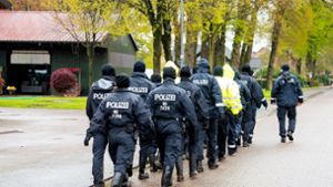 Polizisten gehen auf der Suche nach einem vermissten Jungen durch eine Ortschaft in Niedersachsen. Foto: Daniel Bockwoldt/dpa