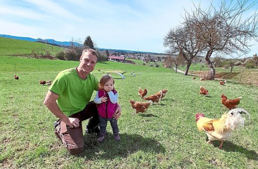 Michael Oesterle mit seiner Tochter inmitten der Hühner Foto: Gern