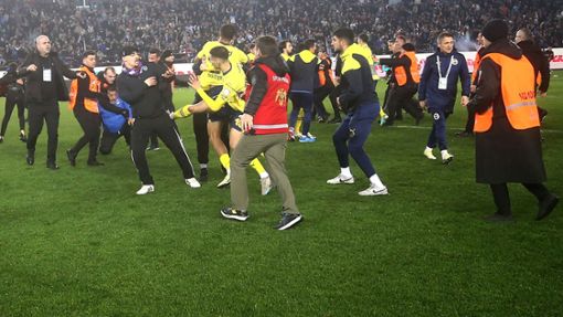 Fans von Trabzonspor haben das Spielfeld gestürmt und Spieler von Fenerbahce angegriffen. Foto: AFP/HANDOUT