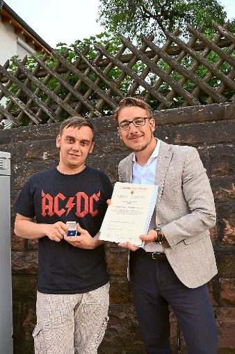 Tobias Roller (links)  wurde von Ortsvorsteher Davide Licht mit der Goldenen Ehrennadel des Deutschen Roten Kreuzes ausgezeichnet. Foto: Bausch Foto: Schwarzwälder-Bote