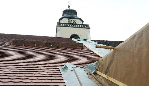 Die Dachsanierungsarbeiten schreiten zügig voran. Während das westliche Kirchendach bereits mit neuen roten Biberschwanzziegeln eingedeckt ist, liegen auf der östlichen Dachhälfte noch die alten Ziegel. Foto: Hopp