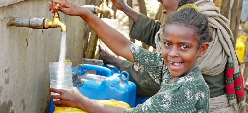 Ein Kind an einem Wasserhahn: Eine Solarpumpe sorgt hier für fließendes Wasser. Foto: Schwarzwälder-Bote